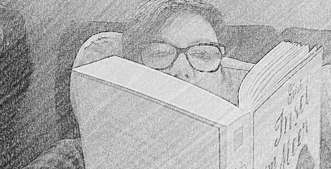 Frau mit Brille liest im Zug in einem Buch