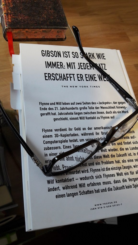 Rückseite des Buches Peripherie mit daraufliegender Lesebrille