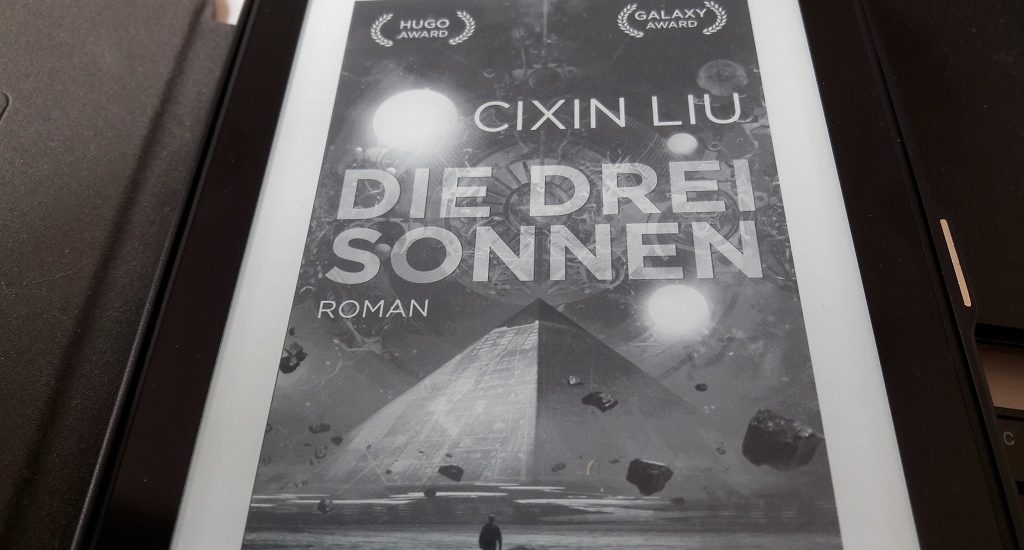 Cover in schwarzweiß, Pyramide vor einem Himmel mit drei Sonnen