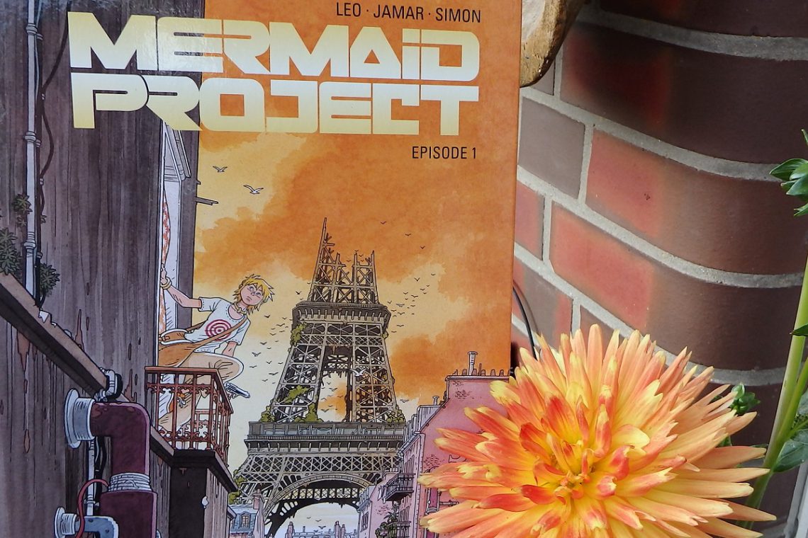 Mermaid Project Titel neben einer großen orangefarbenen Dahlienblüte