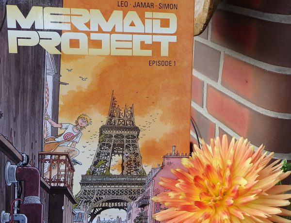 Mermaid Project Titel neben einer großen orangefarbenen Dahlienblüte