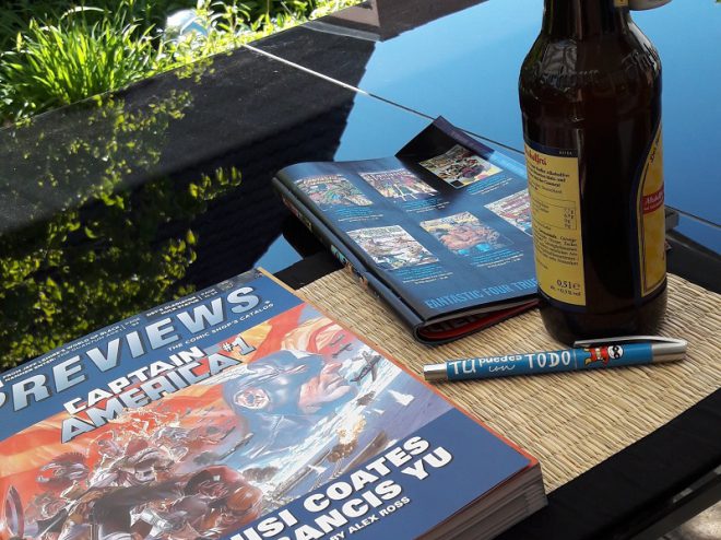 Previews Katalog, daneben die Marvel-Vorschau und eine Flasche Bier im Garten