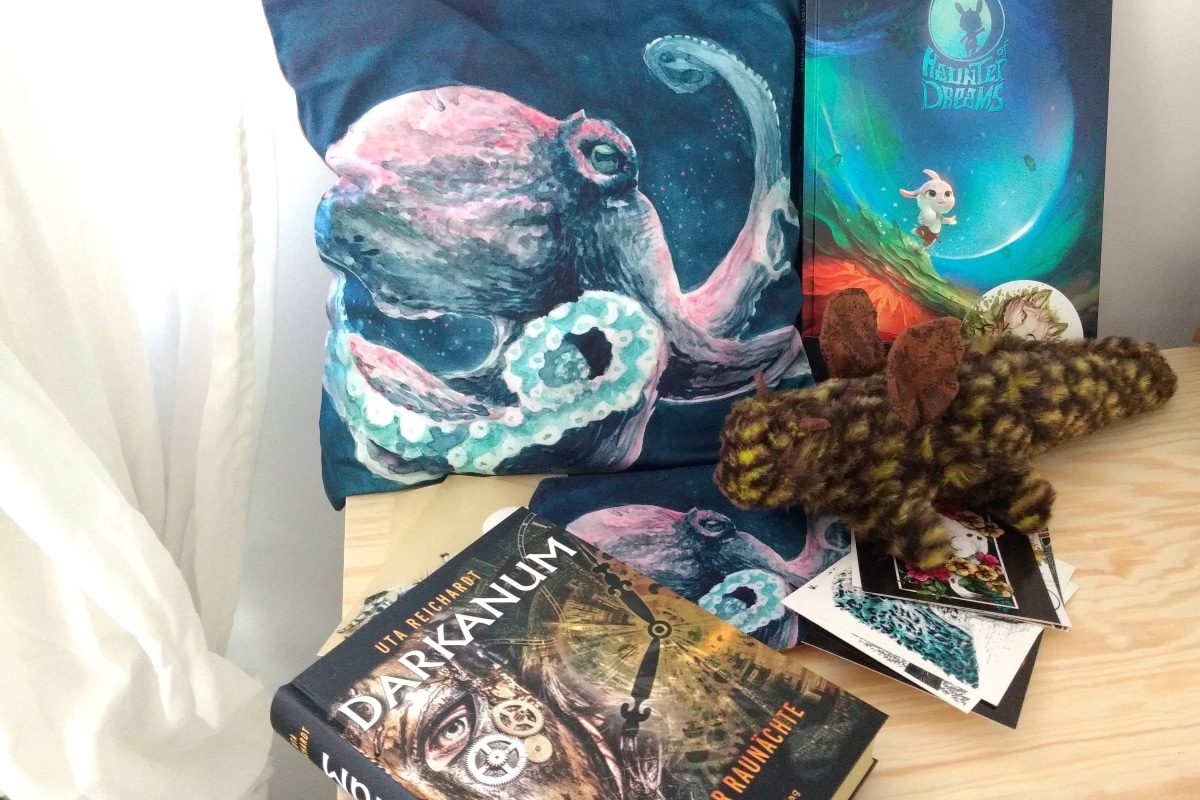Ein Kissen mit Oktupus darauf, daneben ein Comic, davor Postkarten und ein Jugendroman