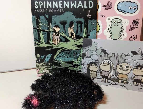 Comic, davor liegt eine schwarze handgehäkelte Spinne