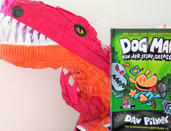 Dog Man Comic neben einem großen roten T-Rex aus Papier