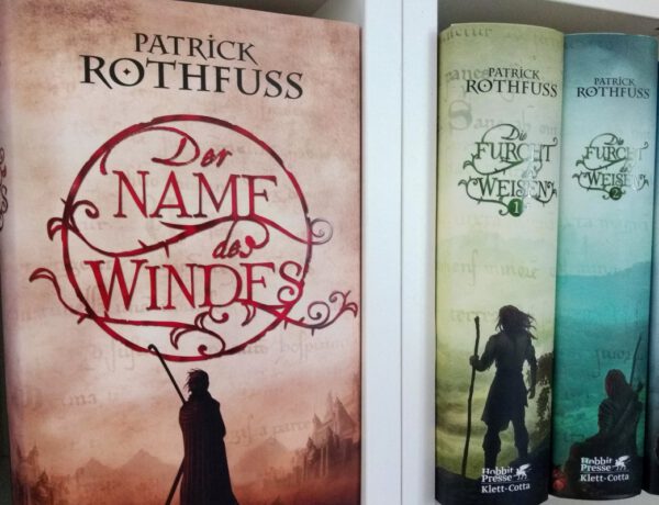 Alle Hardcoverbände von Patrick Rothfuss nebeneinander im Regal