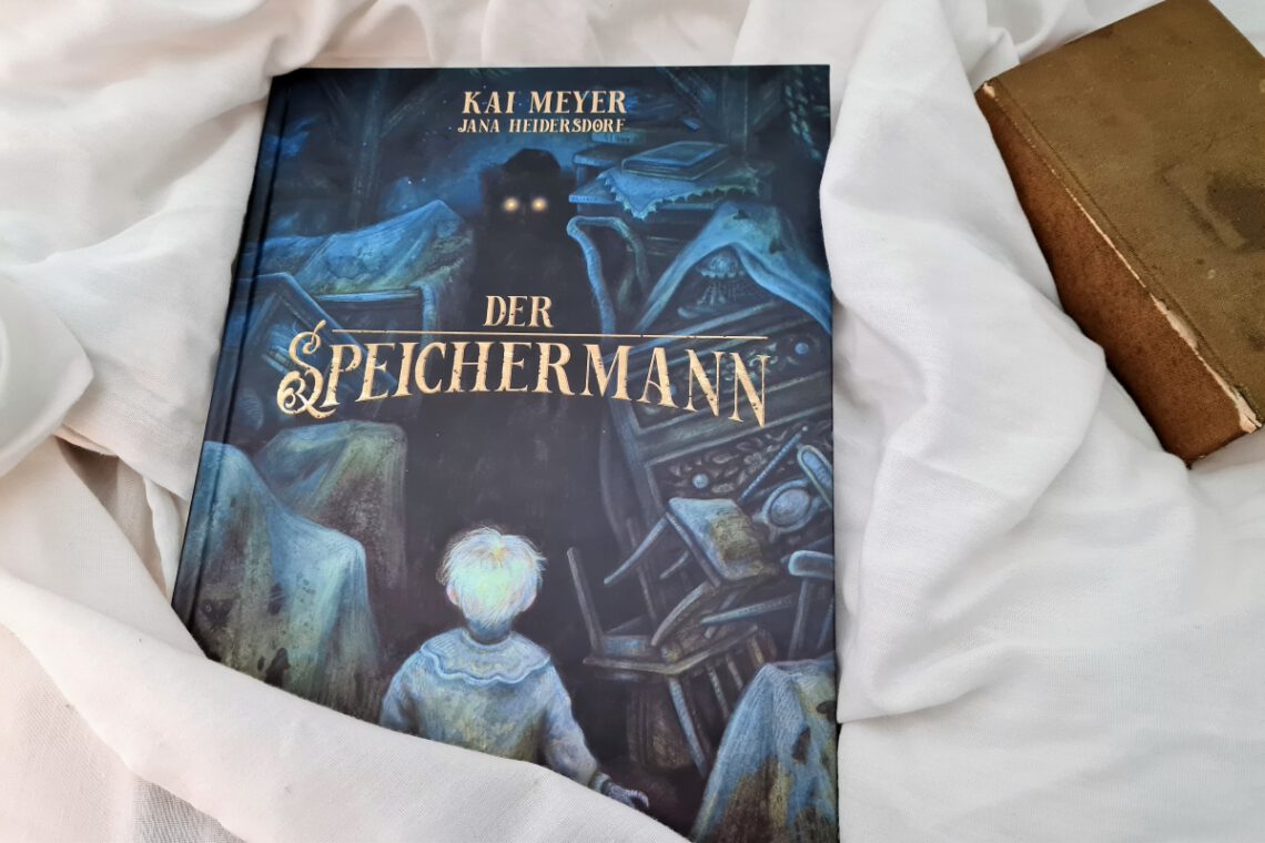 Comic vor einem hellen Tuch und daneben ein altes Buch