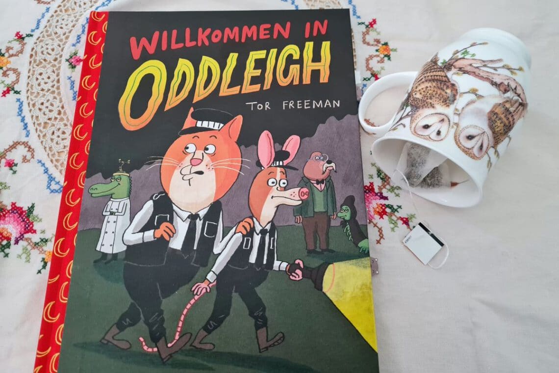 Comic auf einer bestickten Tischdecke und daneben eine Teetasse