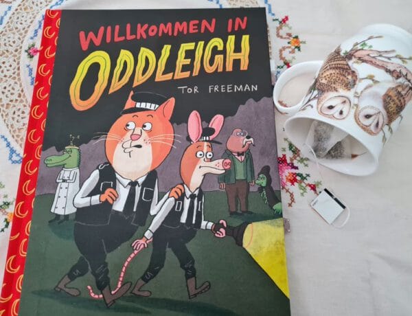 Comic auf einer bestickten Tischdecke und daneben eine Teetasse