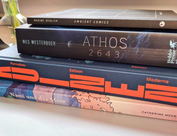 Vier Comics und Bücher auf einem Stapel