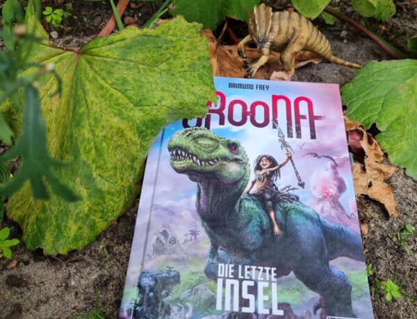Buch mit Mädchen auf Tyrannosaurus Rex liegt auf dem Boden, darüber ein Plastik-Dino