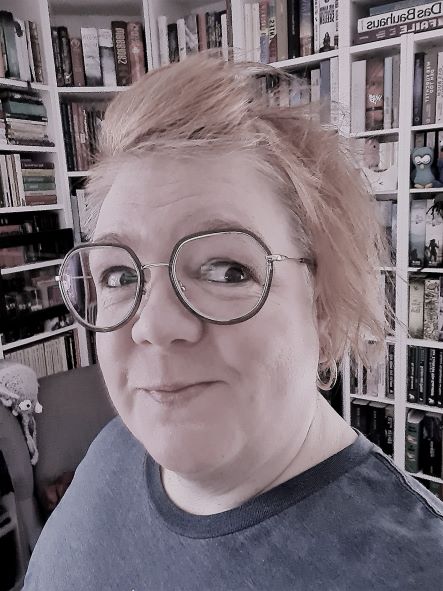 Foto Frau mit Brille vor Bücherregal